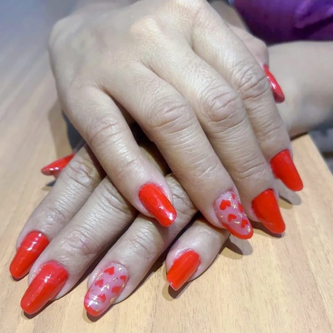 Unhas vermelhas com arte de corações